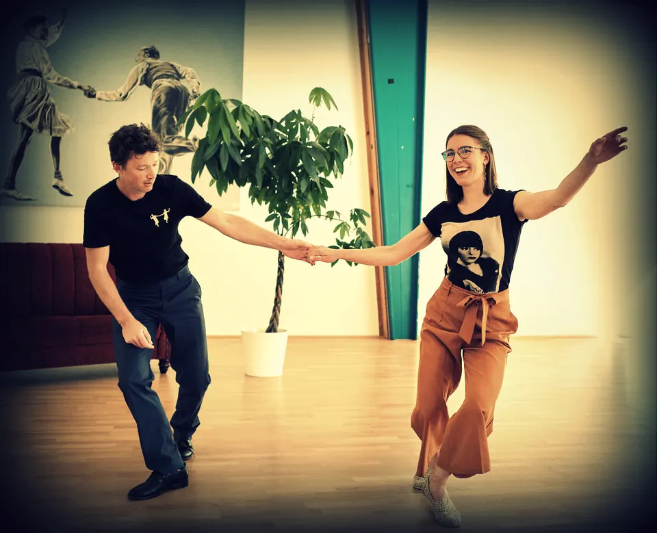 Swing-out au studio : un couple bras tendus, elle rit
