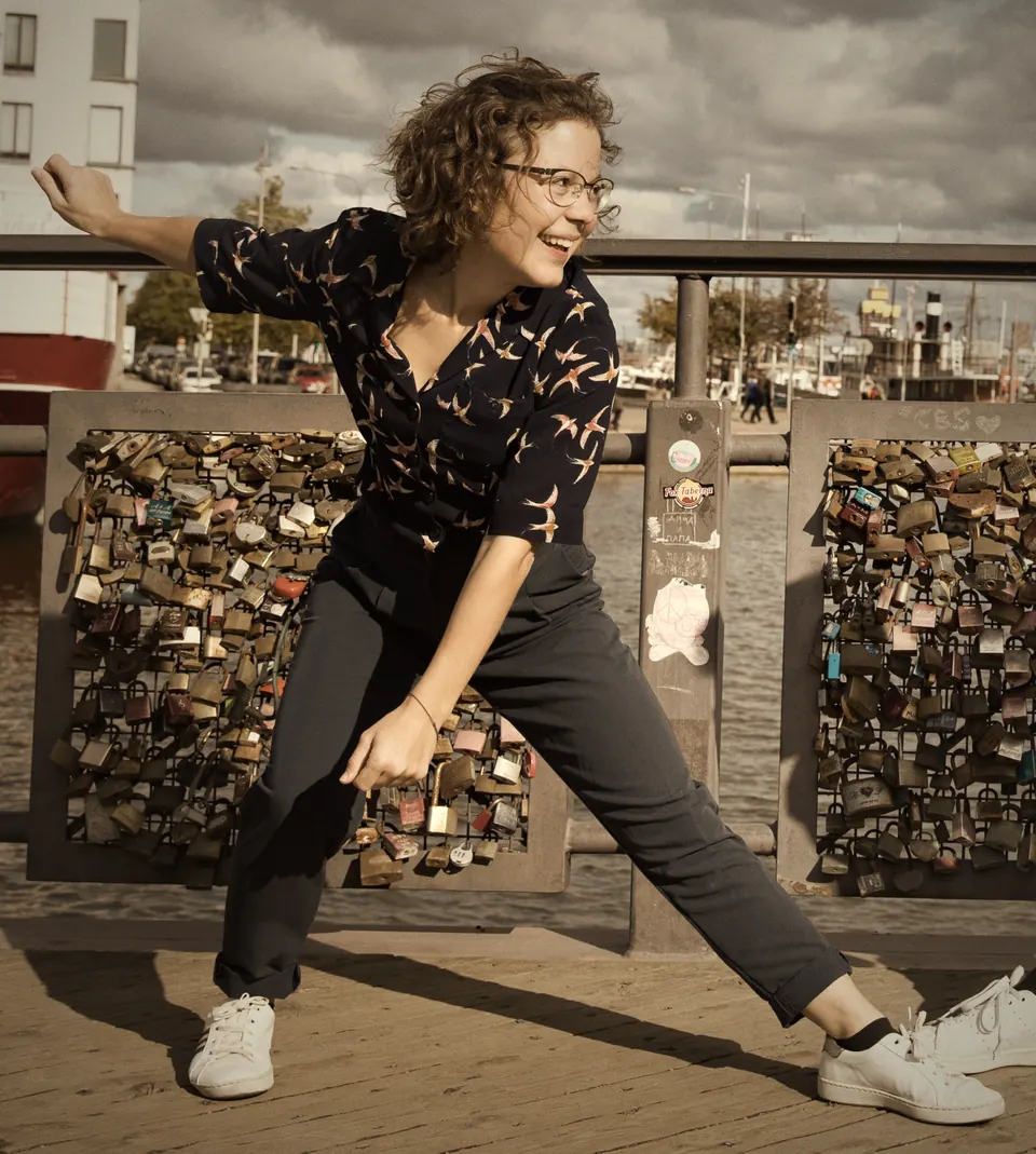 Maren in Solo-Jazz-Pose vor einem Geländer voller Liebesschlösser am Hafen