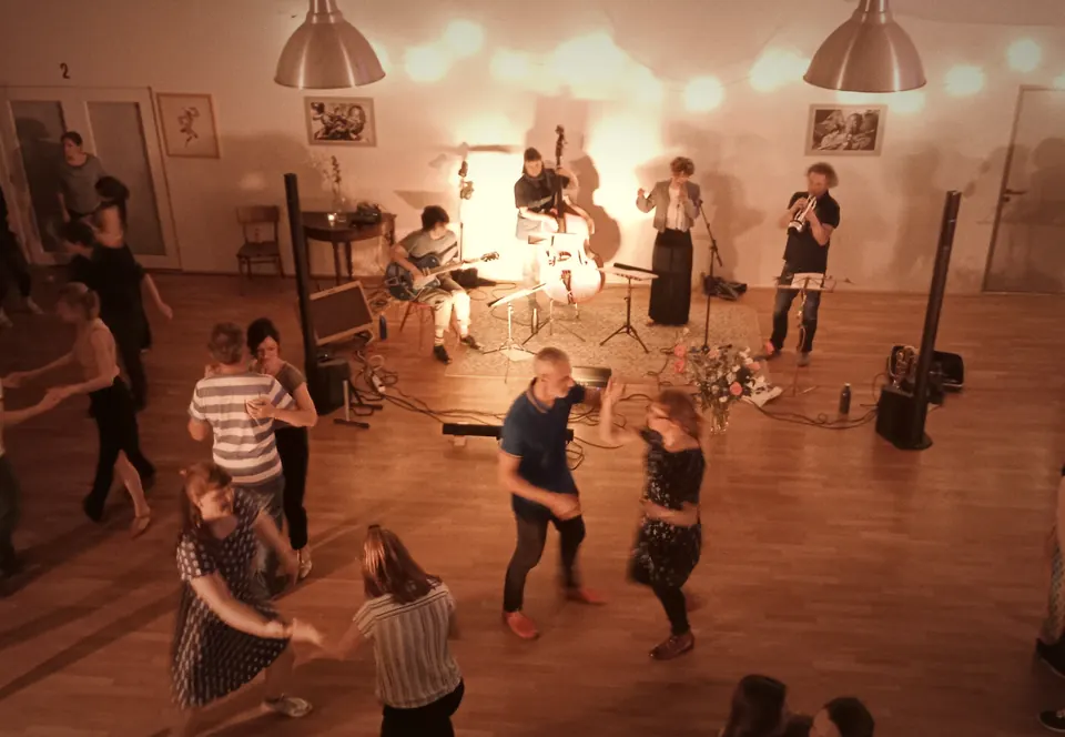 Soirée avec groupe live sous lumière rouge, vue d’en haut, des couples dansent